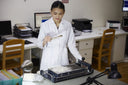 A GOBI quality technician in a white coat checking cashmere fibre at a laboratory bench