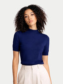 Woman wearing a blue short-sleeve mock top against a light gray background #color_mood-indigo