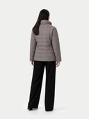 back view of a woman wearing a gray puffer jacket and black pants on a white background #color_dim-gray