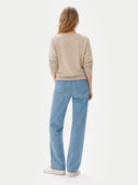 back view of Person wearing a beige sweater and light blue jeans on a white background #color_warm-grey