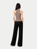 back view of Woman wearing a brown sleeveless top and black pants on a white background #color_taupe
