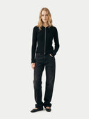 front view of a woman wearing a black zip-up cardigan and black pants on a white background #color_all