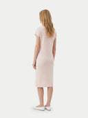 back view of a woman wearing a light medium pink dress on a white background. #color_light-blush