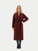 front view of a woman wearing a red long floral coat with tied a belt and black boots on a white background #color_red