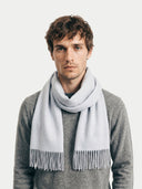 Man wearing a light gray scarf against a plain background. #color_light-gray