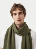 Man wearing a green scarf against a white background. #color_olive-green