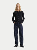 Person wearing a black shirt and dark jeans on a white background. #color_black