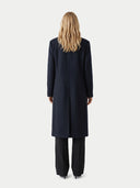 back view of a person wearing a long black coat on a white background. #color_black