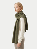 Woman wearing a green scarf on a white background. color_olive-green