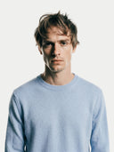 close up front view of a man wearing a light blue round neckline, long-sleeve sweater against a white background #color_light-blue