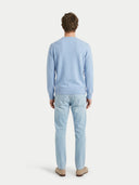 back view of a man wearing a light blue sweater and jeans on a white background #color_light-blue