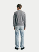 back view of a man wearing a gray sweater and light blue jeans on a white background #color_dim-gray