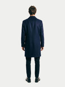 Back view of a man wearing a navy overcoat on a white background. #color_navy