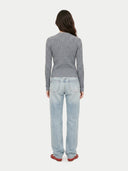 back view of a woman wearing a gray ribbed cardigan and light blue jeans on a white background #color_all