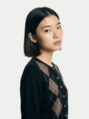 close up front view of a woman wearing a black and brown argyle sweater on a white background #color_black