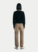 back view of a man wearing a black sweater and brown pants on a white background #color_black