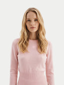 close up front view of a woman wearing a pink sweater against a white background #color_peach-blush