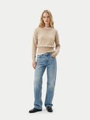 front view of a woman wearing a beige sweater and blue jeans on a white background #color_beige