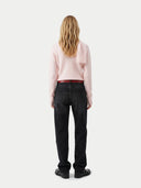 back view of a woman wearing black jeans and a light pink sweater with a scarf on a white background #color_all