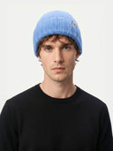 Man wearing a blue knit beanie against a white background. #color_blue