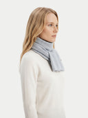 Woman wearing a light gray scarf on a white background. #color_light-gray