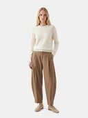 Woman wearing a cream sweater and beige pants on a white background. #color_dark-brown
