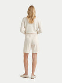 back view of a woman wearing a white outfit with shorts on a white background. #color_pure-white