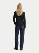 Person wearing a black sweater and blue jeans on a white background. #color_black