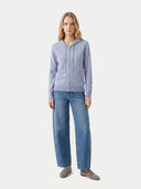Woman wearing a light blue hoodie and jeans on a white background. #color_light-gray