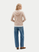 back view of a person wearing a beige hoodie and blue jeans on a white background. #color_beige