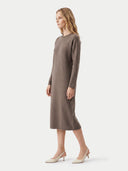 A woman modeling a long-sleeve, knee-length taupe knit dress with a crew neck, paired with cream slingback kitten heels, against a light gray studio background.