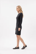 A woman modeling a dark charcoal gray long-sleeve knit dress, paired with dark loafers, shown in profile against a clean white studio background.
