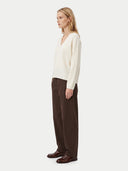 Cardboard cutout of a man in a gray sweater and dark pants on a white background.