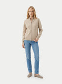 front view of a Woman wearing a beige zip-up cardigan and blue jeans on a white background #color_beige