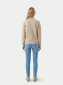 back view of a Person wearing a beige sweater and blue jeans on a white background #color_beige