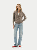 front view of a woman wearing a brown cardigan and light blue jeans on a white background  #color_taupe