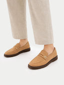 Tan loafers worn with beige pants on a white background #color_almond