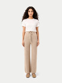 Woman wearing a white t-shirt and beige pants on a white background #color_warm-grey