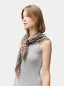 Woman wearing a leopard print scarf on a plain background #color_white