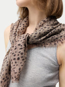 Person wearing a leopard print scarf with a neutral background #color_white
