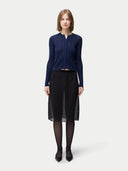 front view of a woman wearing a navy blue button-front cashmere silk cardigan with a crew neckline and black skirt. #color_mood-indigo