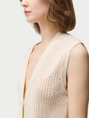 close up of a beige vest with button #color_off-white