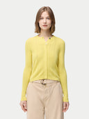 A woman wearing a yellow button-front cashmere silk cardigan with long sleeves and paired with beige trousers.  #color_blazzing-yellow