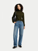 front view of a woman wearing a green sweater and blue jeans on a white background #color_avocado