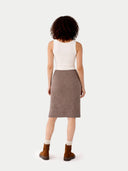back view of a woman wearing a white top and brown skirt on a white background #color_taupe
