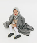 Child wearing a gray hooded coat on a white background