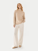 front view of a woman wearing a beige sweater and white pants on a white background #color_beige
