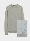 flat lay of a gray crew neckline sweater and fringed scarf on a light gray background. #color_dawn-blue
