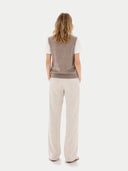 Back-view woman wearing a brown vest and beige pants on a white background #color_taupe