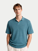 Man wearing a teal polo shirt against a white background. #color_mineral-green